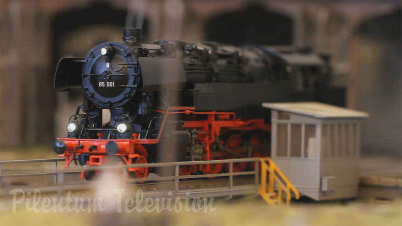 Une jolie maquette de train à l’échelle HO avec des locomotives à vapeur qui fument